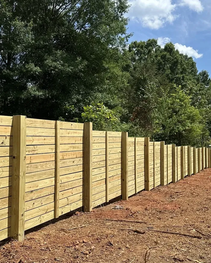 A fence section with new posts reset straight and the old boards rehung